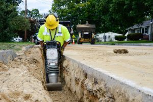 Construction worker using safety equipment on a street project